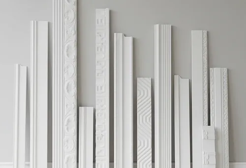 Variety of polystyrene skirting boards in different sizes and shapes displayed against a wall, for selecting suitable interior design