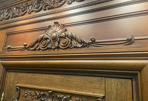 Wooden moldings and decorative door frame trim with carved ornament in classical style