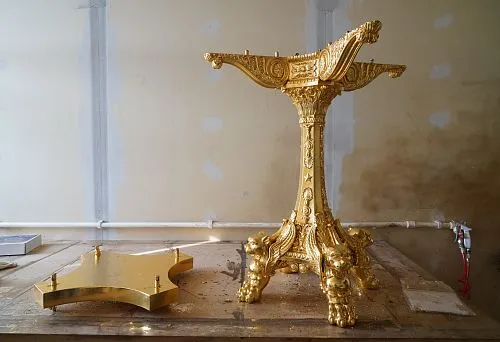 Gilded carved leg of a vintage table with decorative griffin motifs