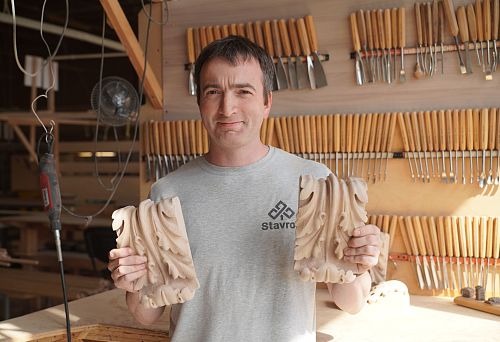 Master with carved wooden wall decorations in the STAVROS workshop