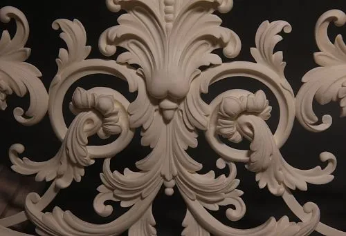 Three-dimensional molded relief in light tone with curved lines and floral elements