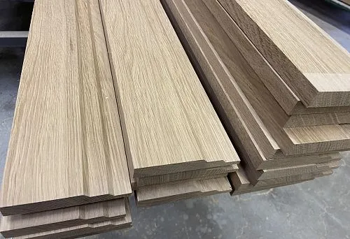 Stack of MDF skirting boards with oak finish, ready for installation