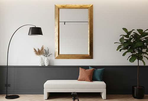 Photo zone in a modern interior: mirror in a golden frame above a dark baseboard, soft bench, floor lamp, and tripod on a light carpet