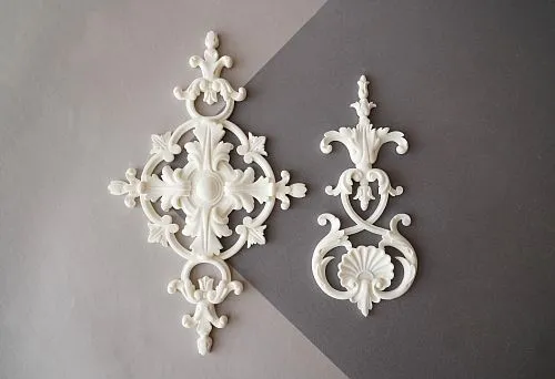 Two elegant decorative elements made of polyurethane with symmetrical patterns