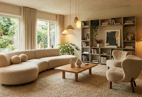 Living Room 2026: boucl&eacute; modular sofa, chair with rounded back, warm light, and shelving with decor