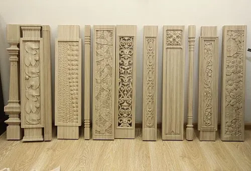 A row of square wooden balusters with artistic carving and various decorative patterns