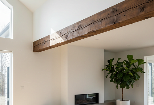 Interior of a Modern Living Room with a Solid Wood Ceiling Beam Emphasizing the Architectural Rhythm of the Space