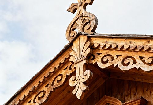 Carved Wooden Facade Decor on House Roof with Traditional Patterns and Architectural Elements