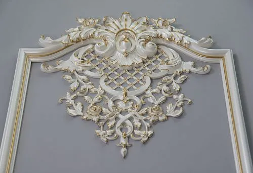 Classic white molding with gold trim and relief floral ornament on walls and ceilings.