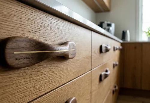 Wooden furniture handle with brass inlay on a solid wood kitchen front