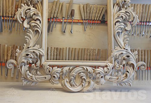 Luxurious hand-carved wooden frame in the workshop, against a backdrop of professional chisels and gouges