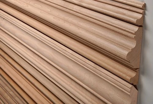 Smoothly finished wooden slats, including samples with round cross-section, laid out in a row