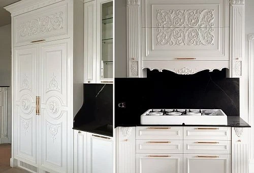 Classic white kitchen with tall carved facades, decorative elements, and built-in gas stove, made of wood.
