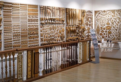 Wall with a variety of carved wooden details, decorative elements, furniture legs, balusters, and ornaments