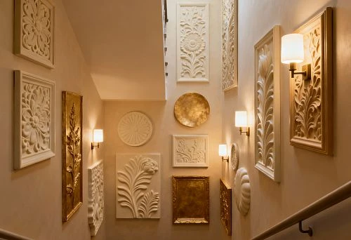 Staircase decorated with polyurethane wall decor, featuring dimensional panels and "before and after" photos of interior transformation