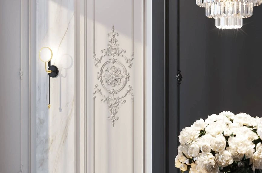 Brussels stucco medallion on a white wall panel next to a marble insert and sconce