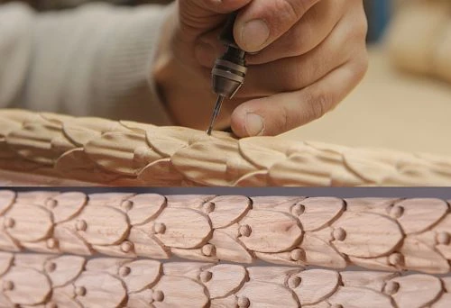 The craftsman manually cuts thin decorative elements into the wooden part, creating a carved pattern for the sofa