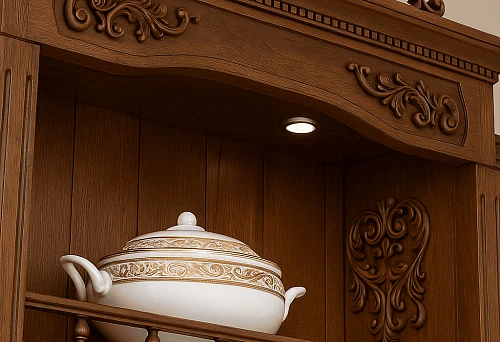 Classic wooden cabinet with exquisite carving and decorative elements, adorned with gold-finished tableware.