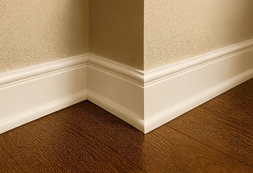 White large baseboard at the junction of wooden floor and wall in interior