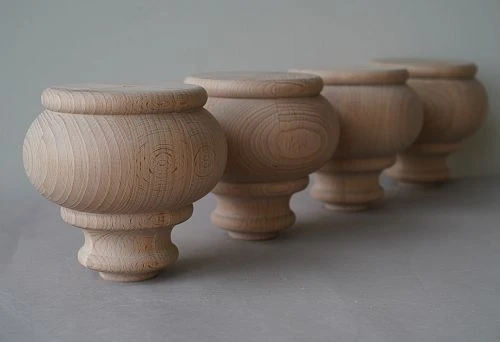 Four precisely crafted wooden furniture supports arranged in a row, showcasing the natural wood grain.