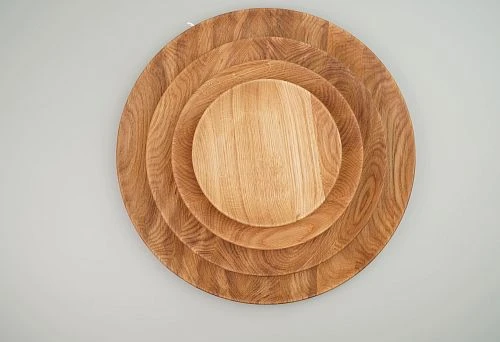 Set of Round Wooden Plates of Different Sizes, Neatly Stacked on Top of Each Other.