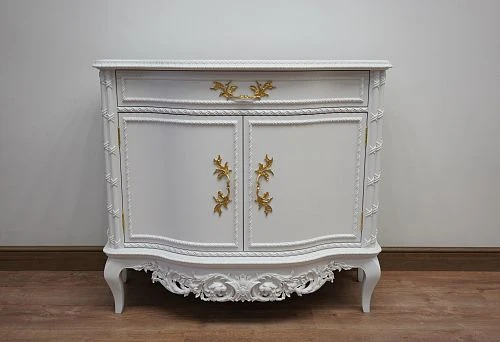 White carved chest of drawers with gilded decorative elements in a classic style