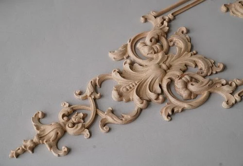 Close-up of a carved wooden element with complex shape, showcasing fine detailing