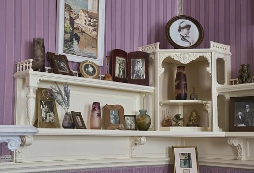 Elegant Carved Shelves with Vintage Vases and Family Photographs.