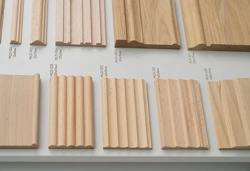 Various profiles of wooden planks on a stand for interior decoration.