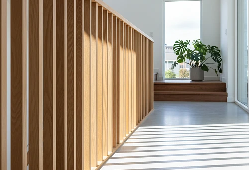 Modern Straight Wooden Balusters from Light Beech Along a Staircase in a Sunny Interior with Large Windows