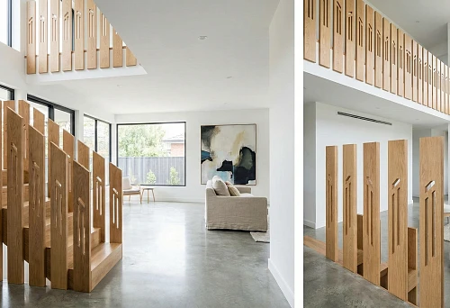 Modern staircase with flat wooden balusters: vertical shields made of natural wood, minimalist interior, light walls, concrete floor.