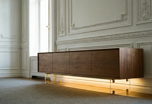 A chest of drawers on transparent supports with lighting creates the effect of "floating" furniture against the backdrop of textured walls with stucco and moldings.