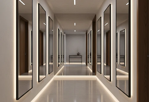 Long corridor with vertical mirrors in black frames, aligned along a single line above the baseboard, and soft perimeter floor lighting
