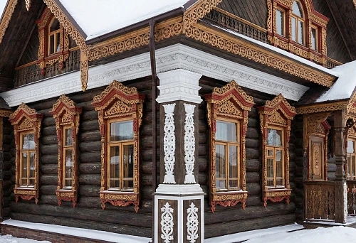 Russian-style facade: carved window frames and a white polyurethane facade cornice