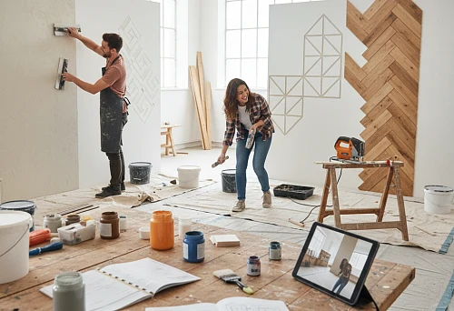 A man applying decorative plaster to a wall during a DIY renovation.
