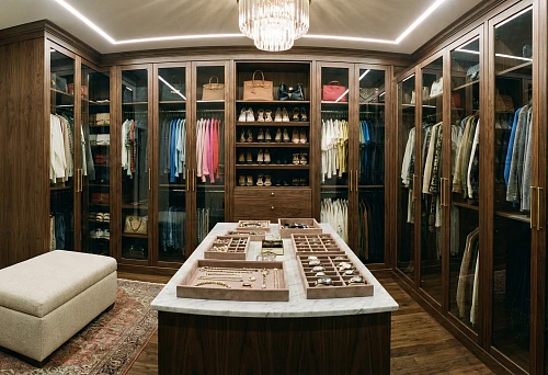 Furniture for dressing room: dark wood cabinets with glass fronts around the room