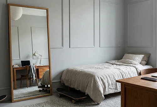 Teenager's room with a floor mirror in a wooden frame, high white baseboard, and simple wall moldings