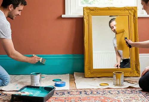 Painting the baseboard in turquoise and painting the mirror frame in yellow to create a bright colorful interior
