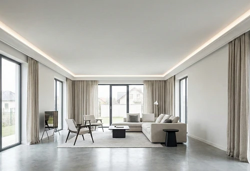 Modern living room with ceiling perimeter and hidden lighting: smooth ceiling, light line along the contour, large windows and neutral furniture.