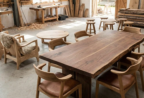 Custom solid wood interior furniture: large dining table and chairs in a carpentry workshop