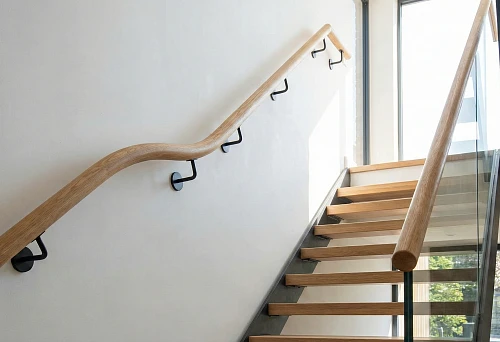 Round wooden handrail for stairs: material selection, installation, and aesthetics in a modern interior