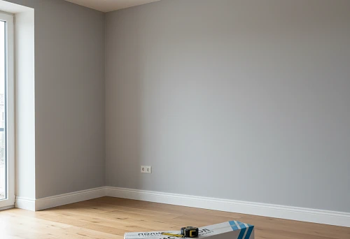 White polystyrene skirting board in a modern interior with wooden flooring and soft ceiling lighting