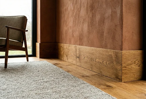 Wide oak wooden skirting board along the wall in a modern interior with a panoramic window.