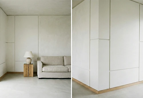 Minimalist interior with smooth wall panels and thin wooden skirting board instead of molding
