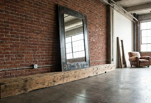 Industrial loft: brick wall and concrete floor, rough solid wood baseboard along the wall