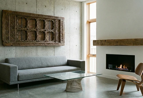 Modern living room with a concrete wall and a carved solid wood panel above the sofa