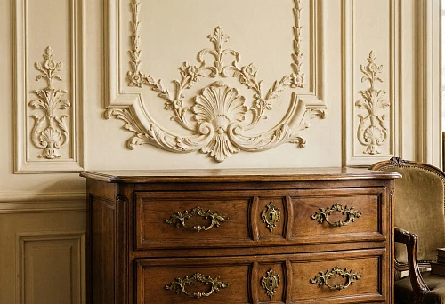 Classic wall with stucco relief and chest of drawers: furniture handles with bronze fittings selected to match the wall stucco ornament