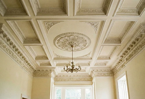 Polyurethane ceiling molding: cornices and a chandelier rosette in a classic interior