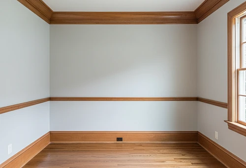 Interior with wooden skirting board, cornice, and profile elements forming a unified decorative line around the perimeter of the room
