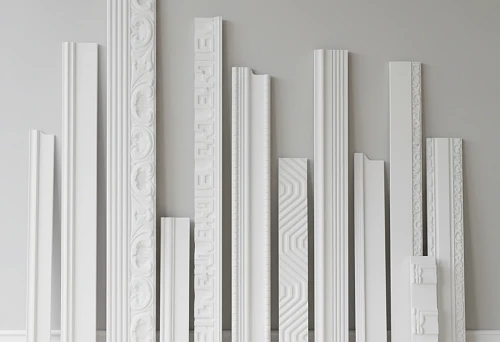 Variety of polystyrene skirting boards in different sizes and shapes displayed against a wall, for selecting suitable interior design